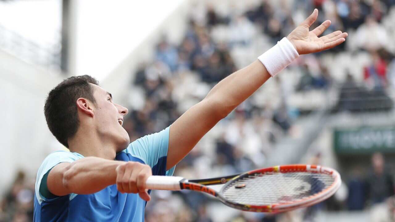 Bernard Tomic serves.