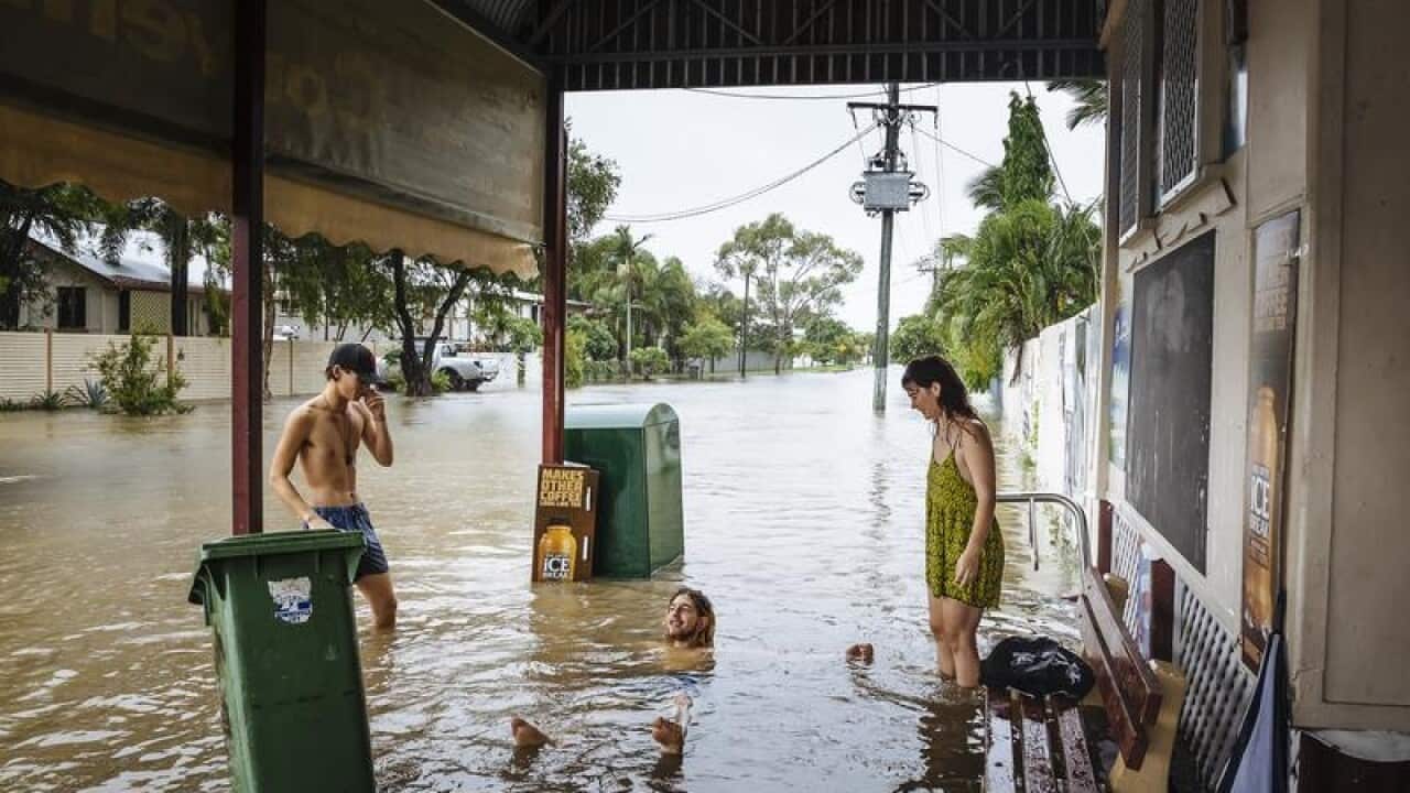 Residents walk through floodwaters in Townsville.