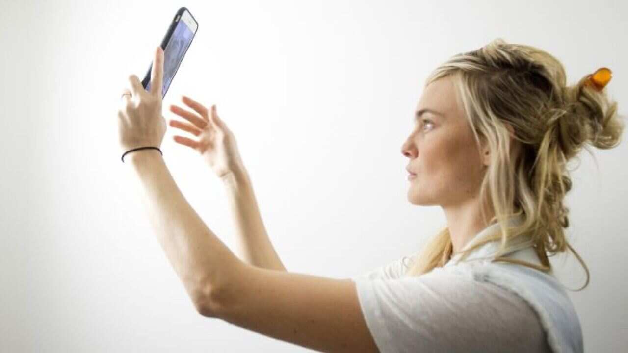 A model poses for a selfie backstage before the Michael Kors Spring/Summer 2016 collection presentation during New York Fashion Week in New York, September 16, 2015.