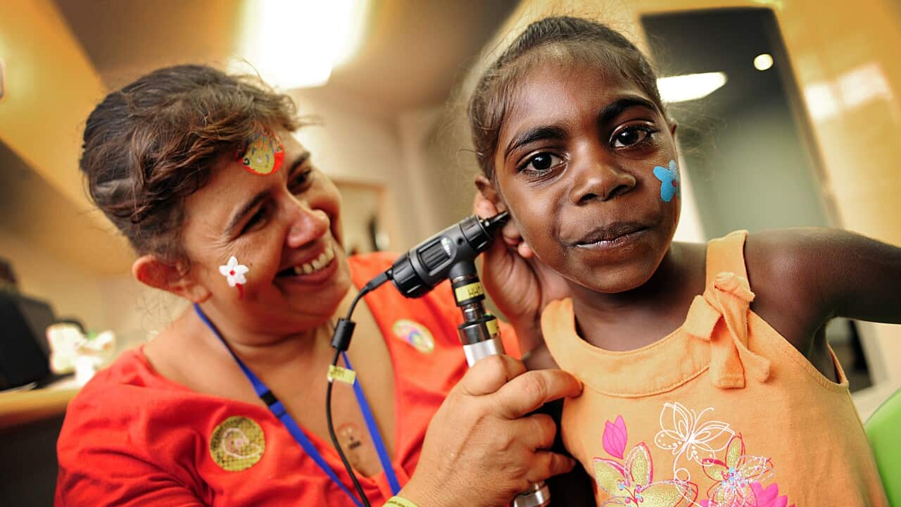 File photo: Sandy Nelson checks the ear of Kirsty Dumoo during the opening of the Wadeye Health Centre.