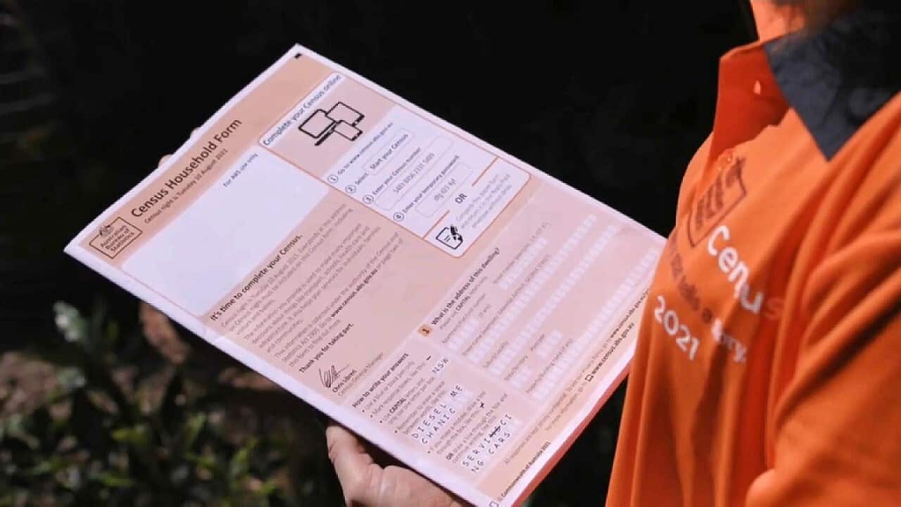 A Census staff member holding a census form (SBS).
