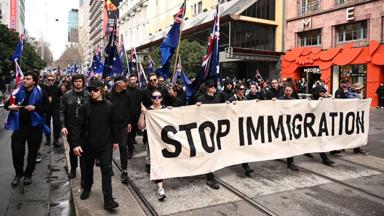 A group of demonstrators holding signs and banners.