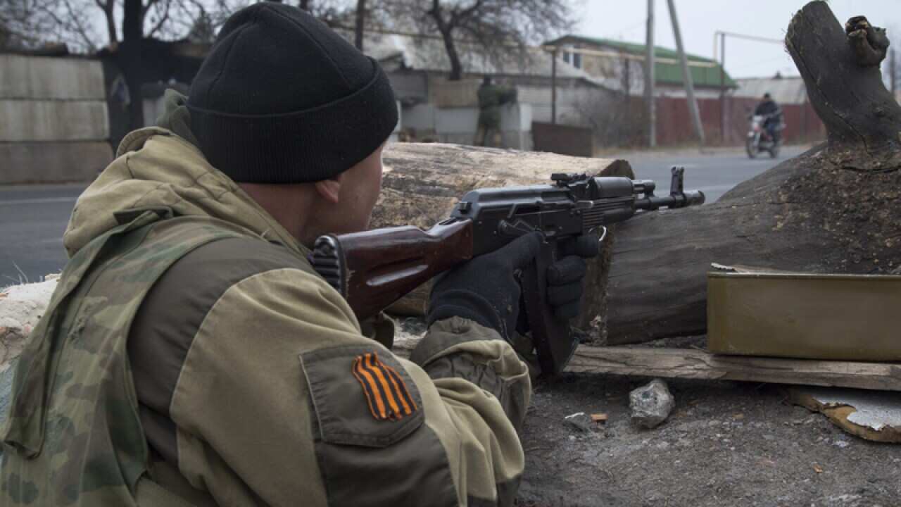 A pro-Russian rebel takes aim at a firing position at a check point