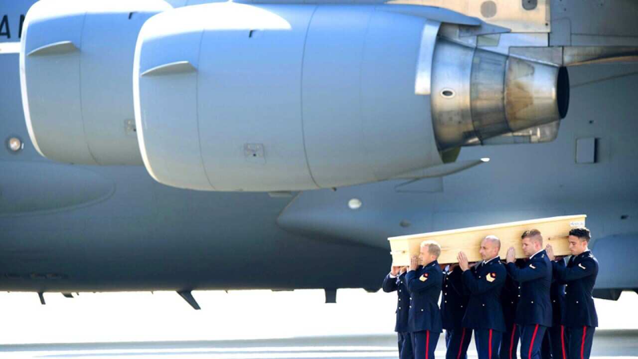 Dutch military personnel carry a coffin
