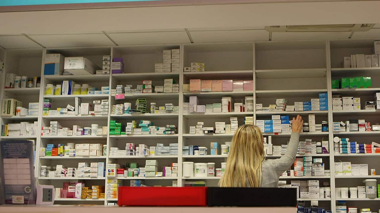 A pharmacist stocking shelves at a chemist.