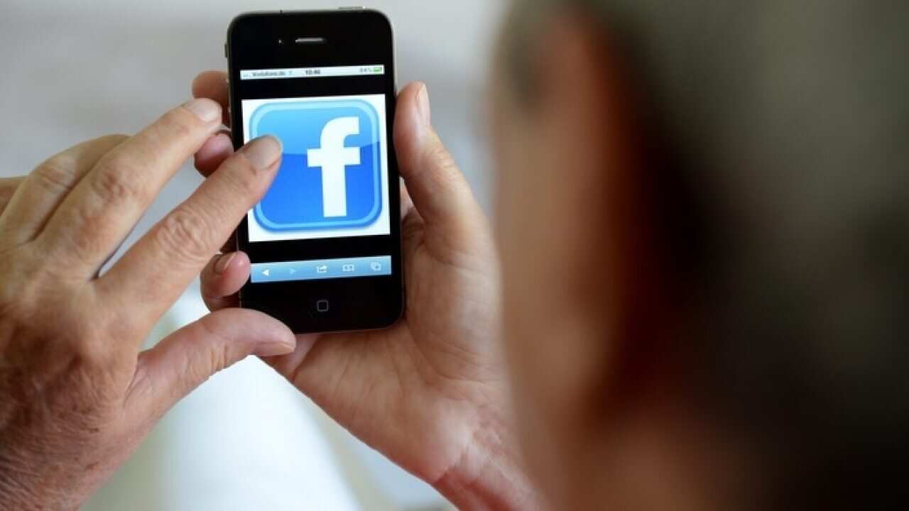 An older woman using Facebook on her phone