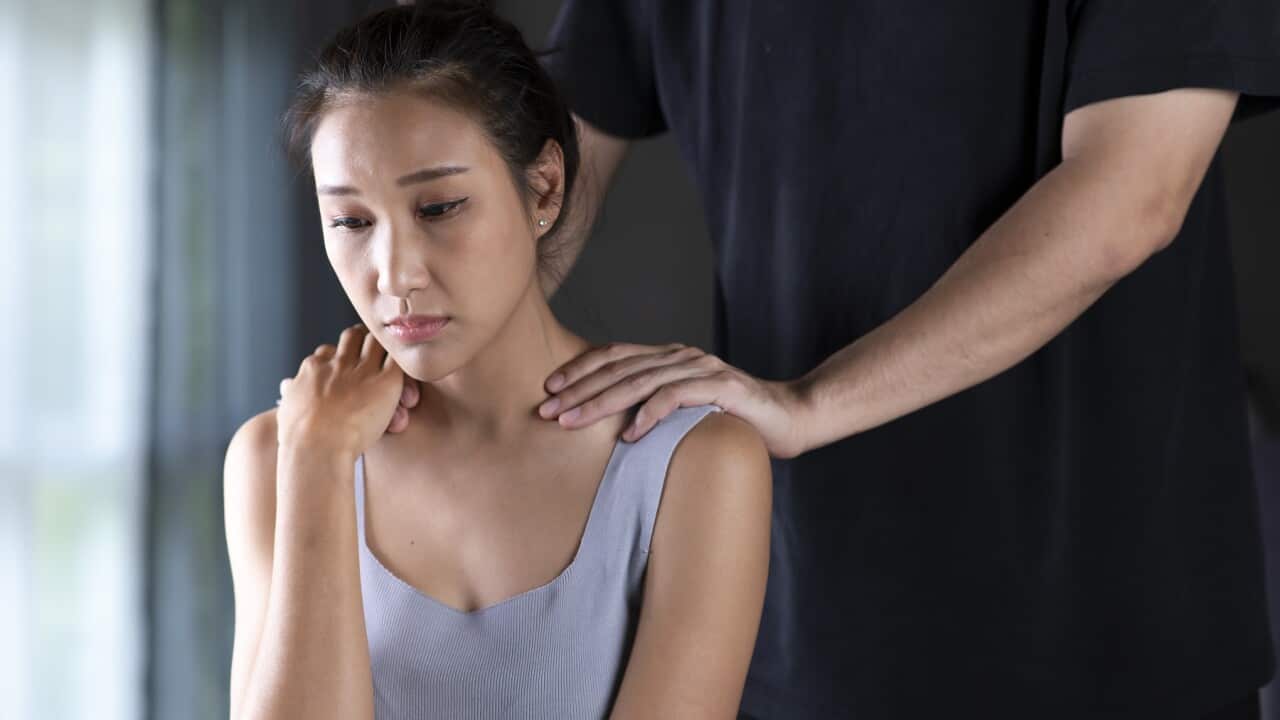 Sad woman being comforted by a man behind her