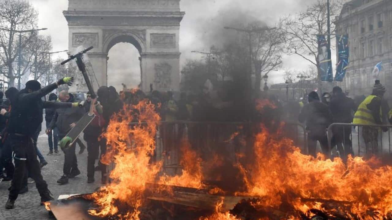 Police and protesters clash on the Champs Elysees
