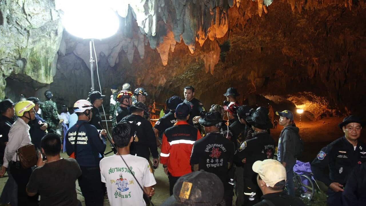 Thai rescue workers and associated officials plan a rescue operation for 12 football players and their coach outside the Tham Luang cave.