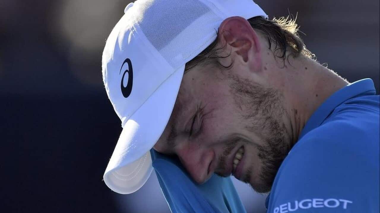 Belgium's David Goffin wipes the sweat from his face.