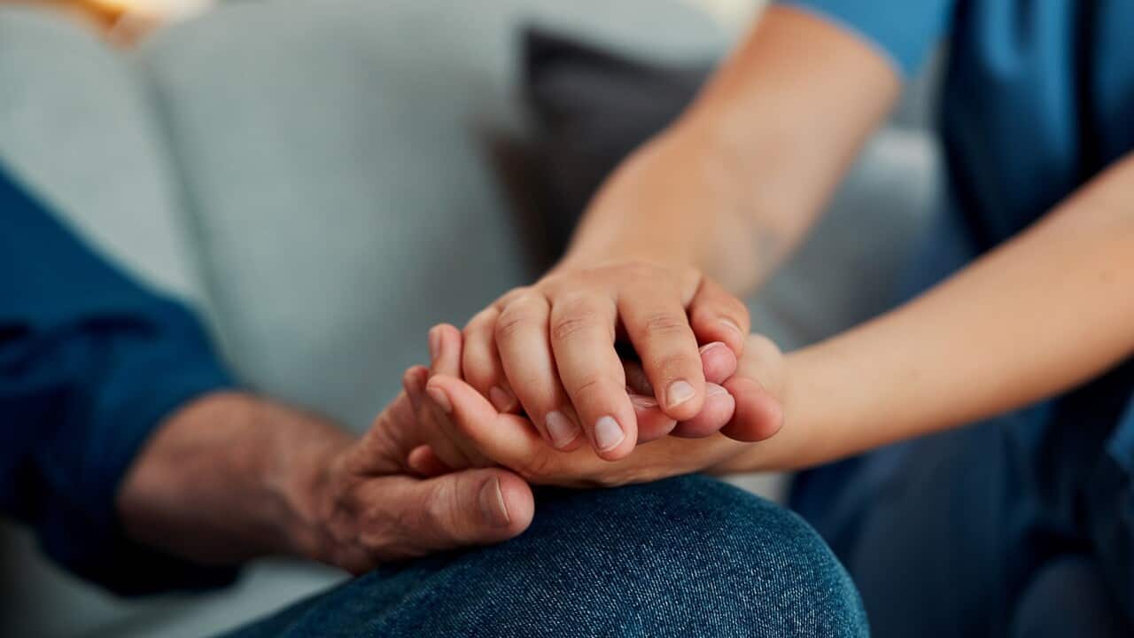 Hand holding, caregiver and man on sofa with elderly care, support or checkup in rehabilitation. Closeup, healthcare and nurse in home with consultation, trust or medical service in retirement.
