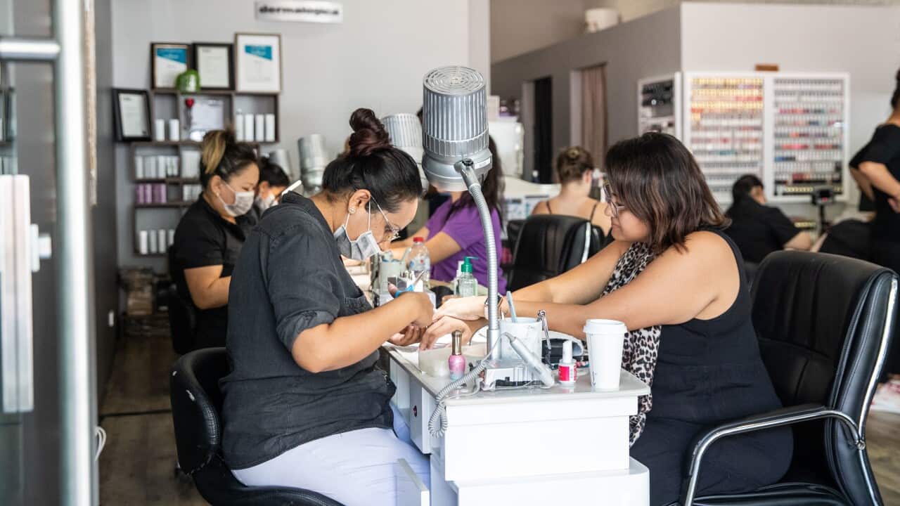 Cre8tive Nails owner Rosie Thind with customer in Darwin, Friday, May 15, 2020. The Northern Territory has lifted a range of restrictions but social distancing is still required. (AAP Image/Helen Orr) NO ARCHIVING