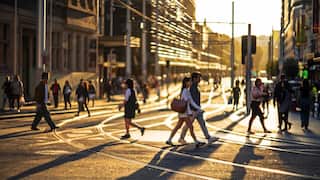 Pedestrians crossing city street at dusk