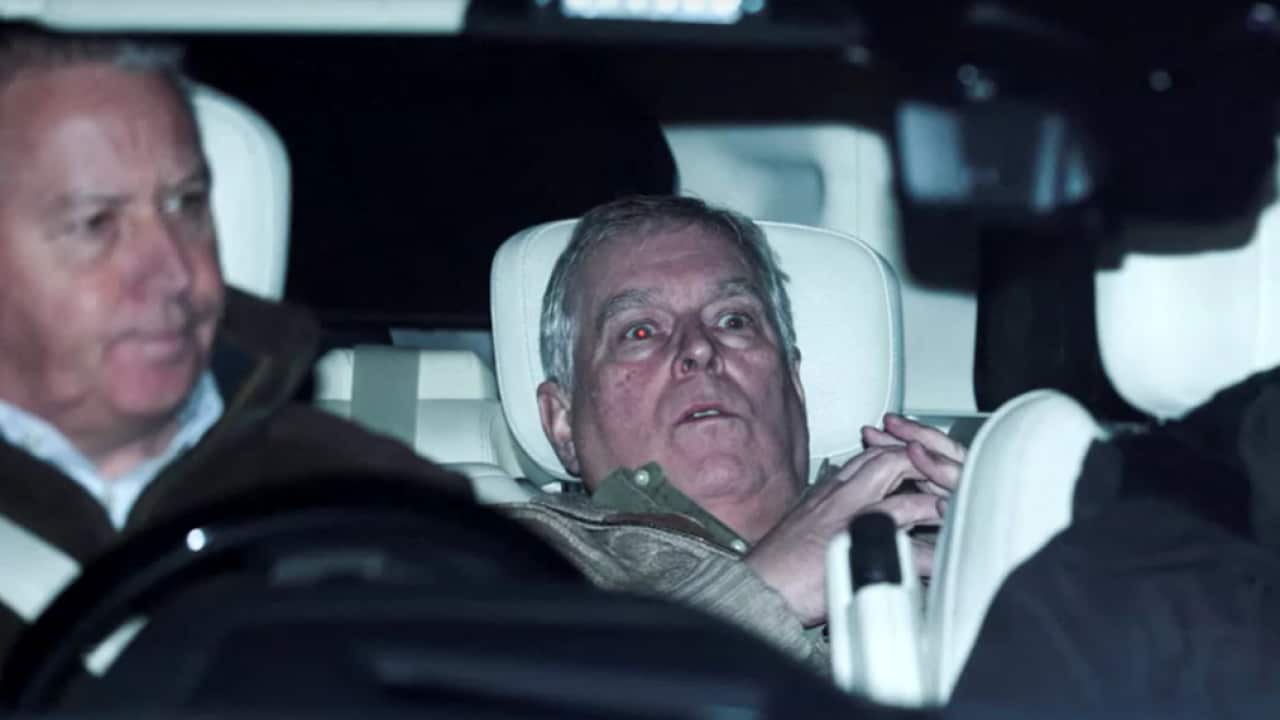 Andrew Mountbatten-Windsor with a shocked expression in the backseat of a car.