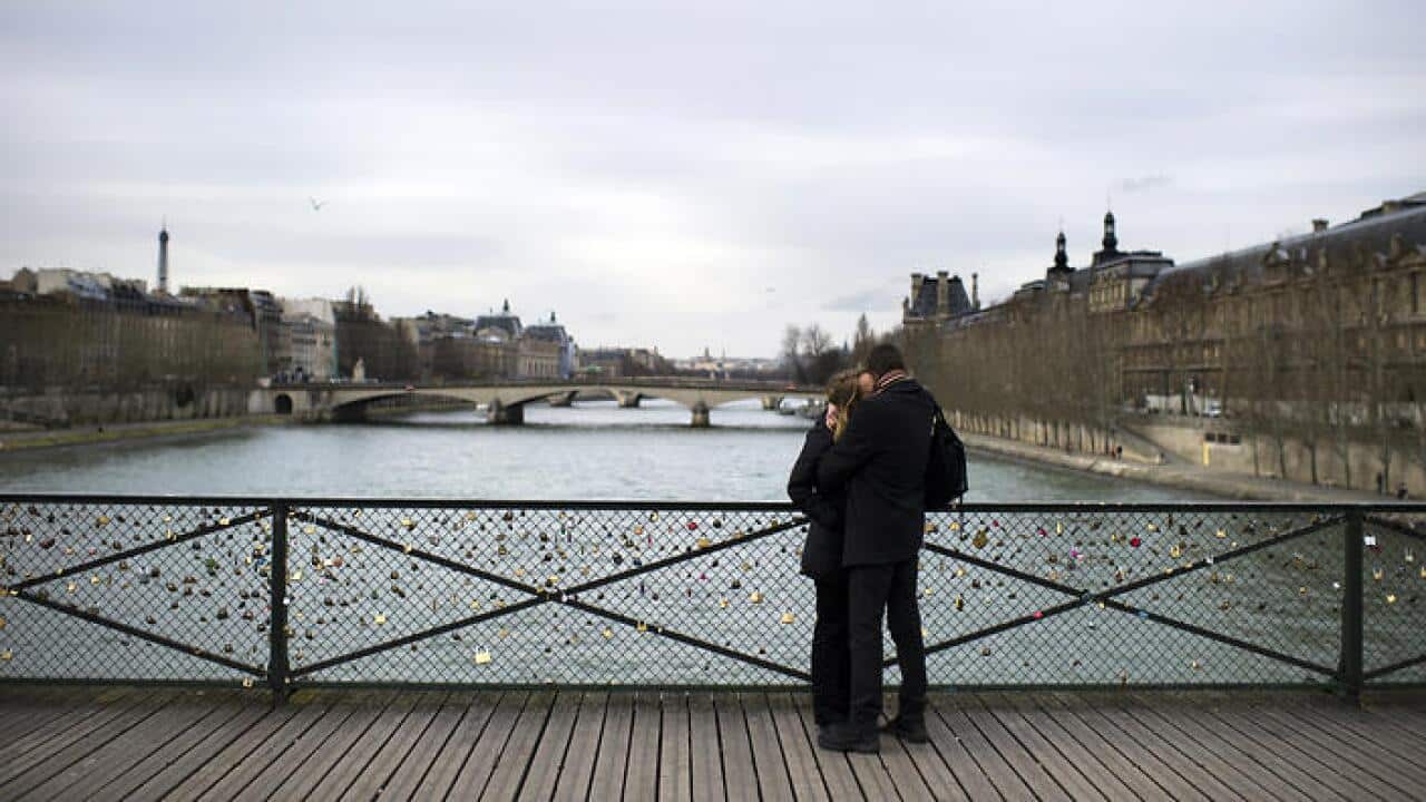 A couple kisses on the Pont des Arts