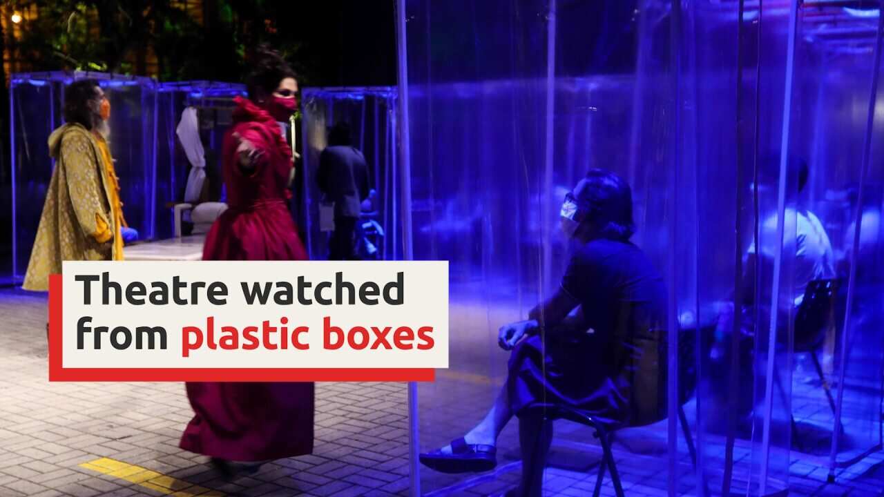 Spectators sit in plastic boxes as theatre returns to Brazil