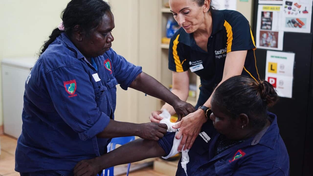 Care Flight nurse Jayne Sheppard (centre) teaches Thamarrurr Rangers how to tourniquet (SBS).
