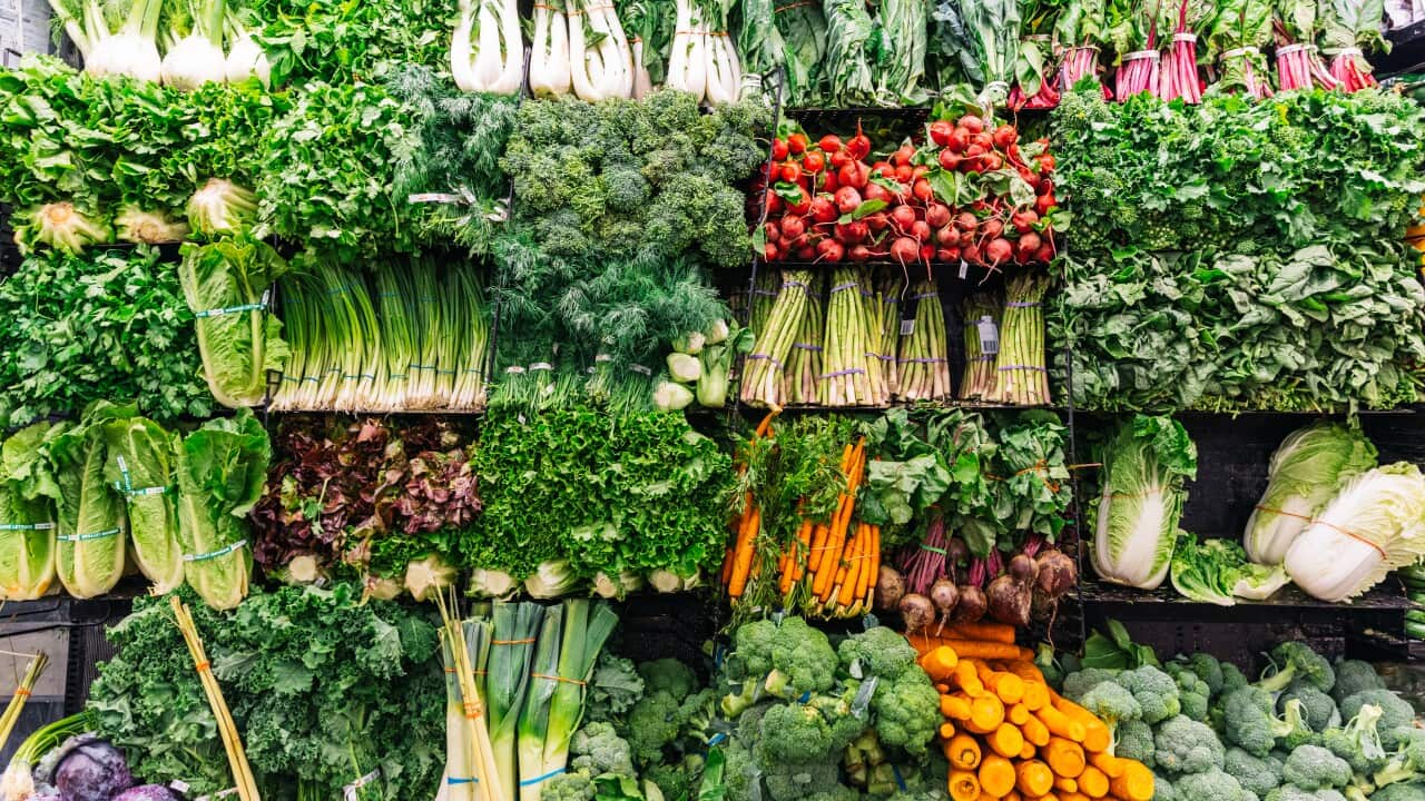 Fresh greens and vegetables on a display in a supermarket