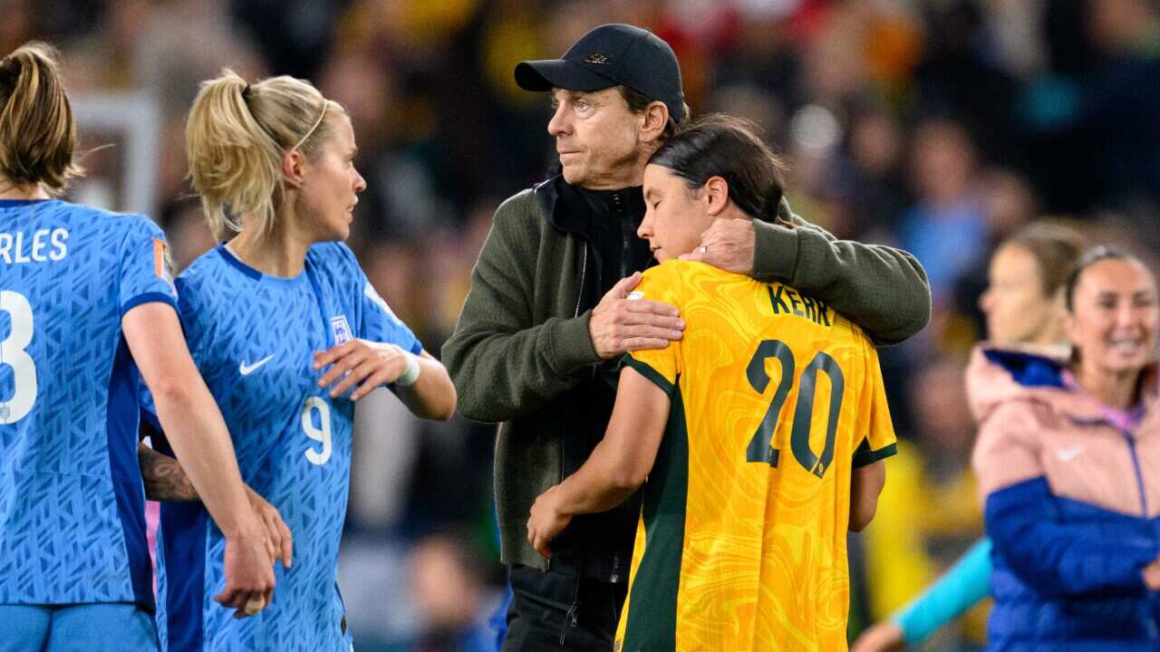Tony Gustavsson hugs Sam Kerr on the field. There are two England players to their left.