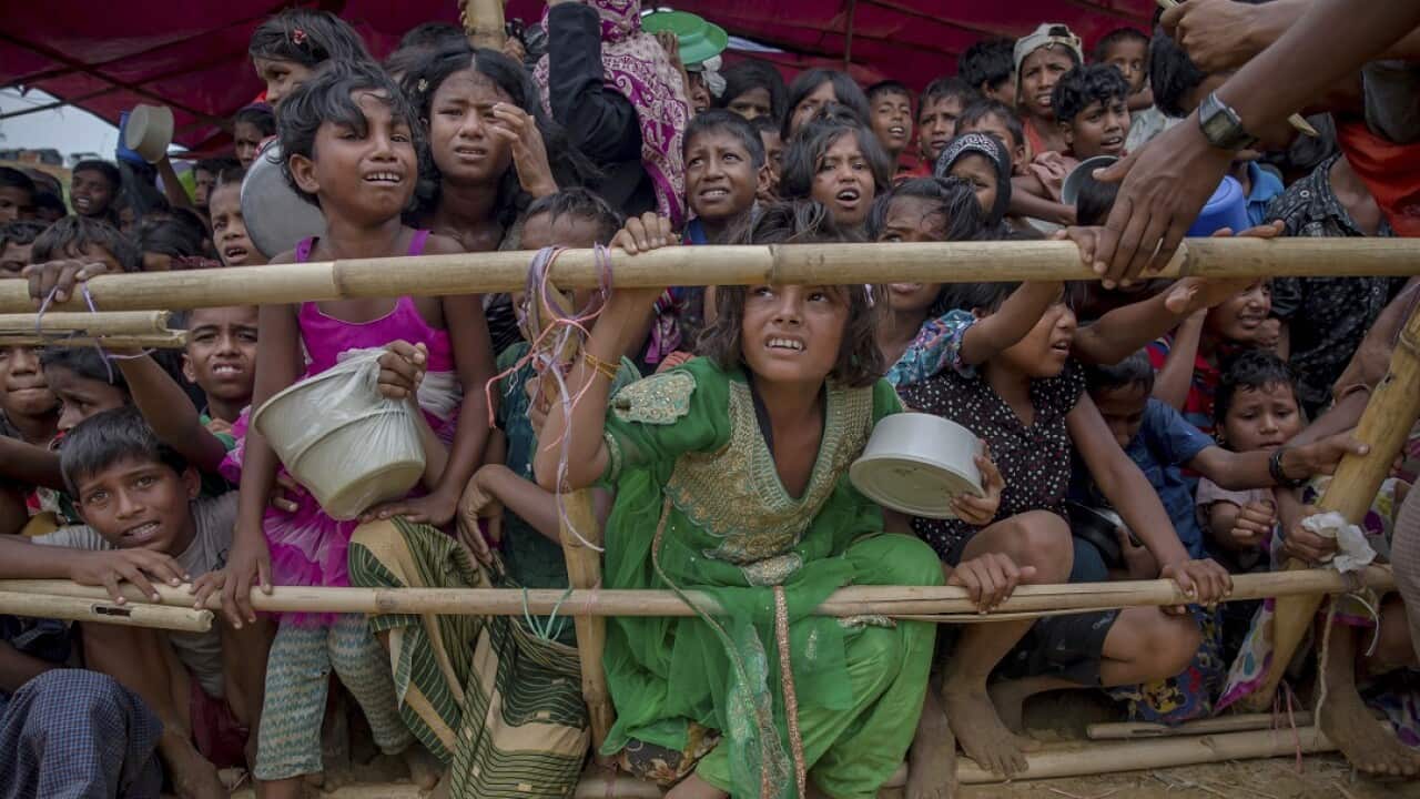 Rohingya Muslim children, who crossed over from Myanmar into Bangladesh, wait for their turn to collect meals distributed by Turkish aid agency.