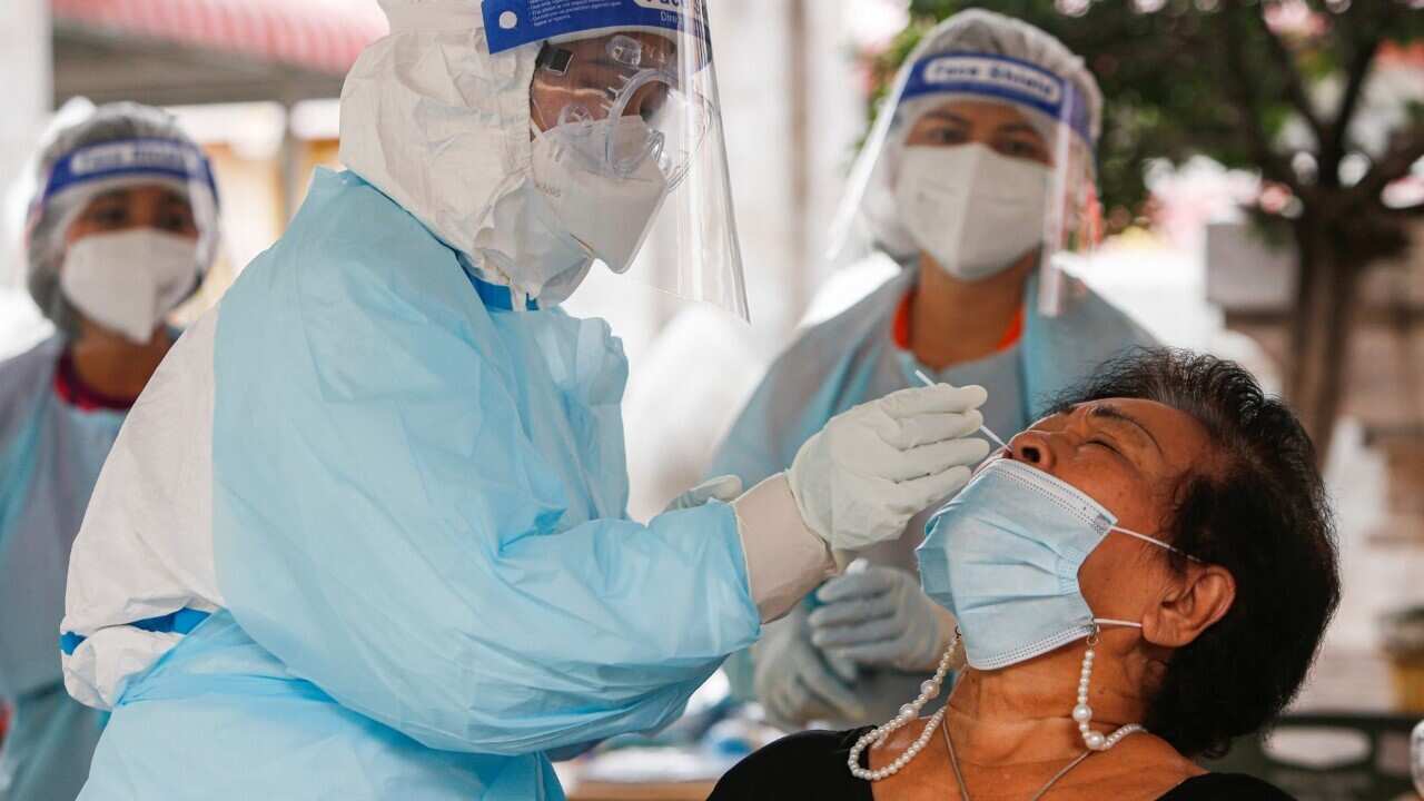 Collecting a nasal swab sample from a woman in Bangkok (AAP Image-Chaiwat Subprasom -SOPA Images-Sipa USA)