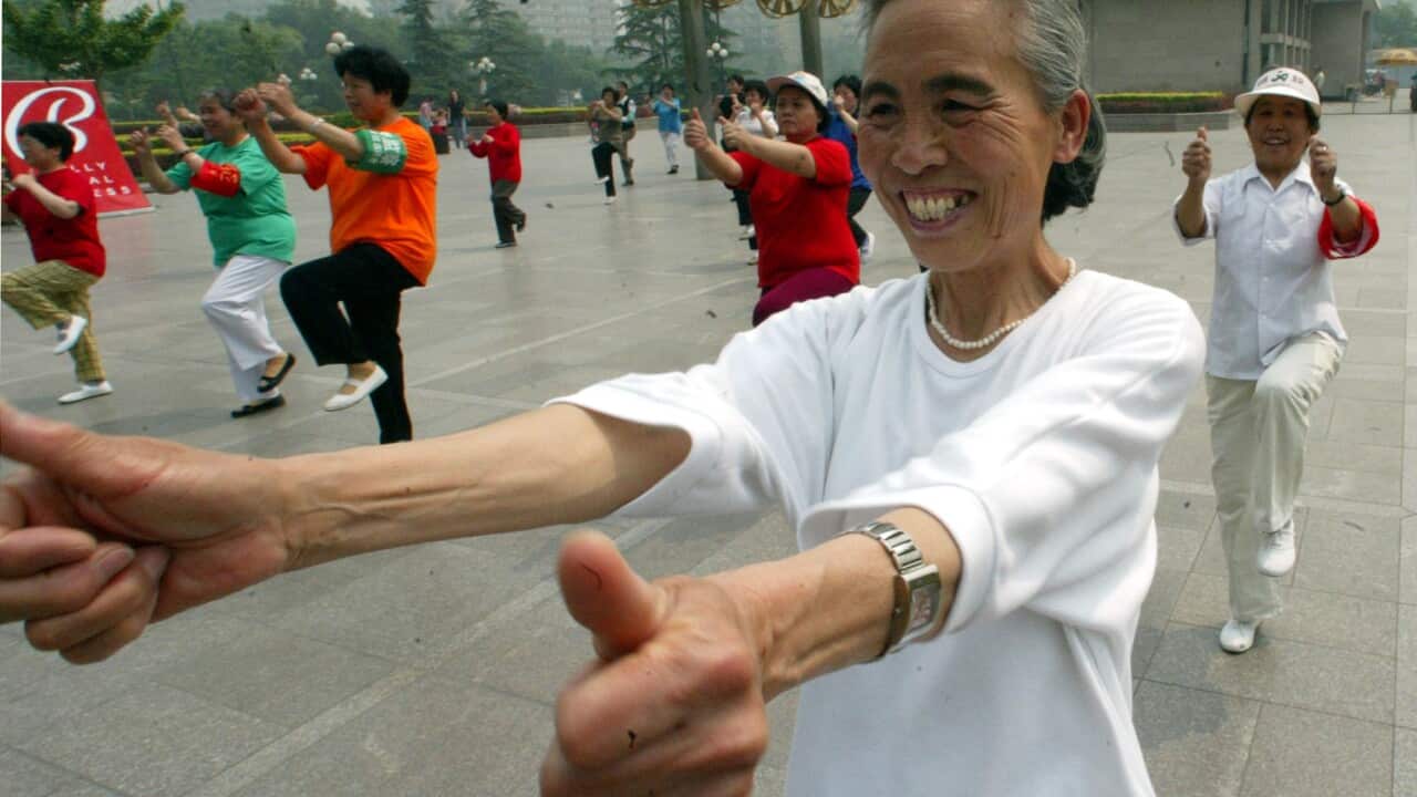An elderly Chinese lady exercising with others at a park in Beijing, China, Wednesday, May 21, 2003. Fitness has taken on a new significance as Beijingers are encouraged to stay healthy inorder to keep SARS away. (AP Photo/Ng Han Guan)