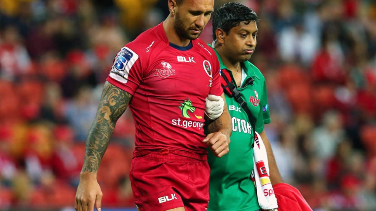 Quade Cooper of the Reds leaves the field injured