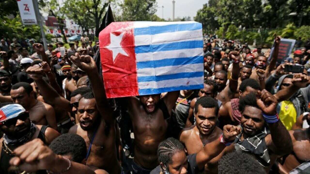 A Papuan activist holds up a separatist “Morning Star” flag during a rally near the presidential palace in Jakarta, Aug. 22, 2019.
