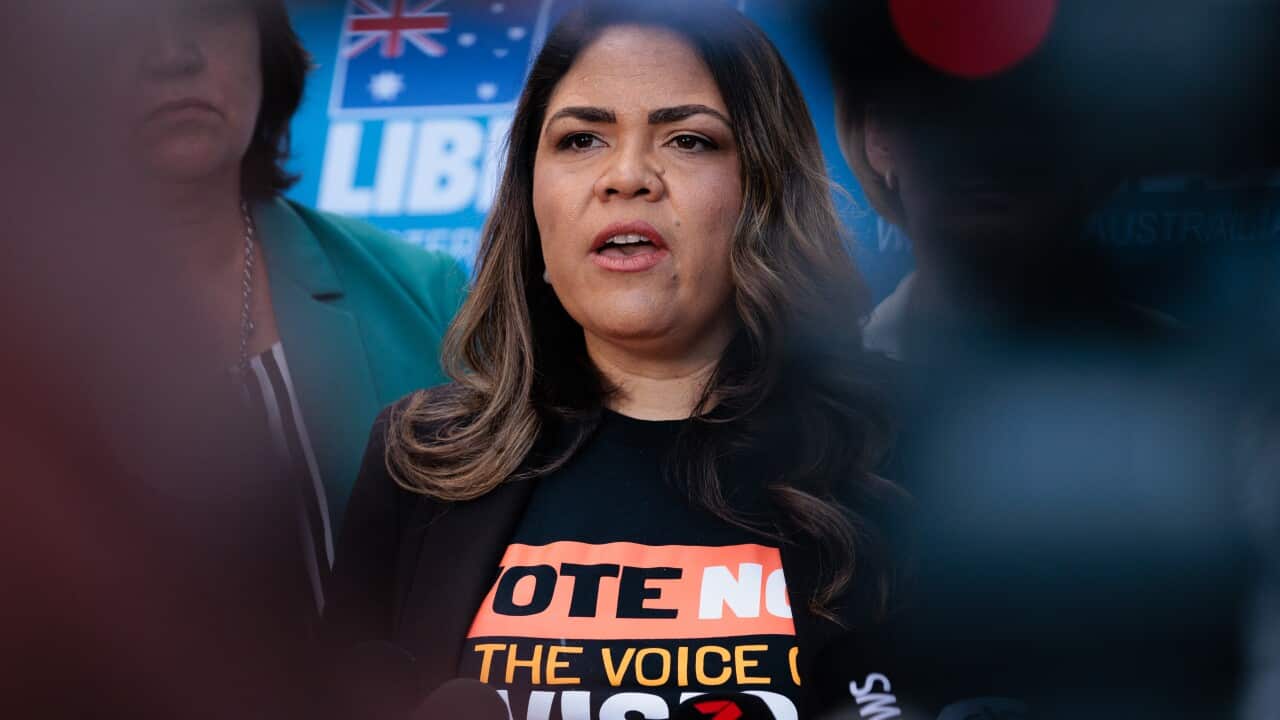Woman in a Vote no T-shirt speaking.