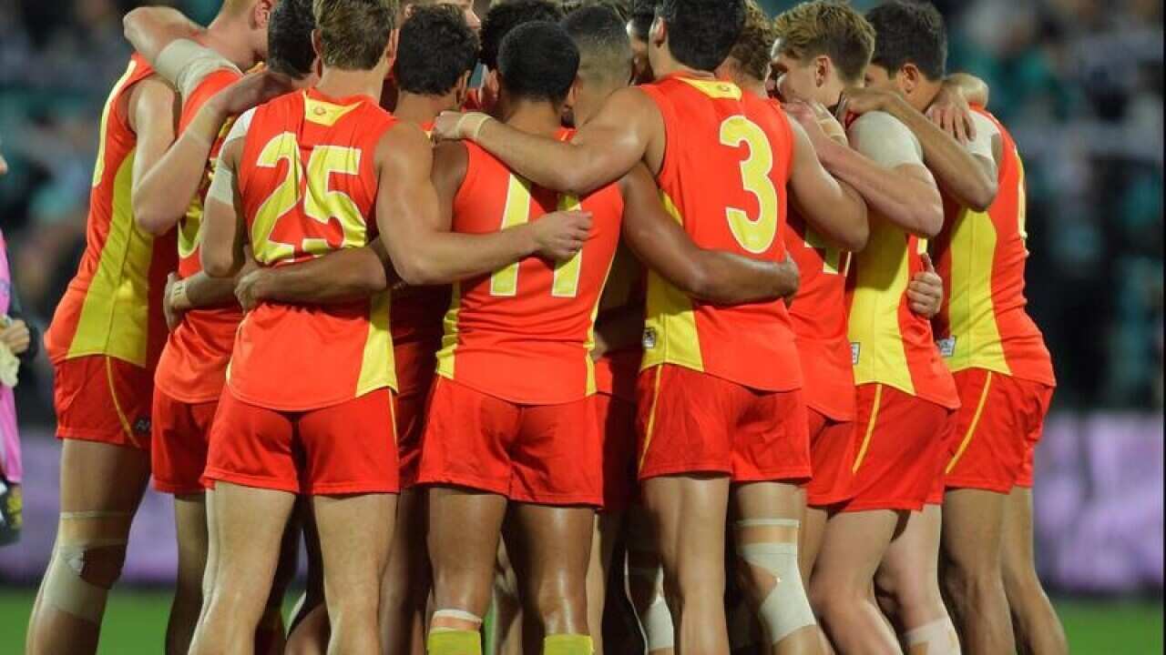 Gold Coast Suns players huddle during the Round 23.