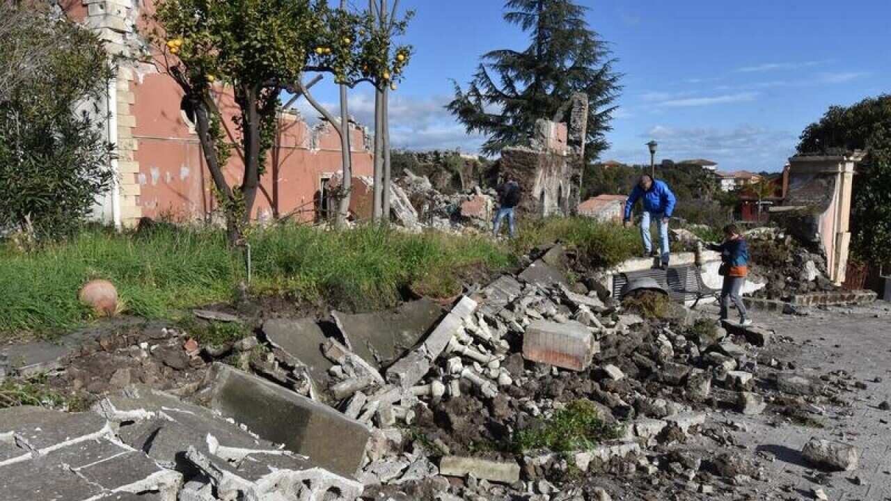 Debris in front of a damaged building in the city of Catania
