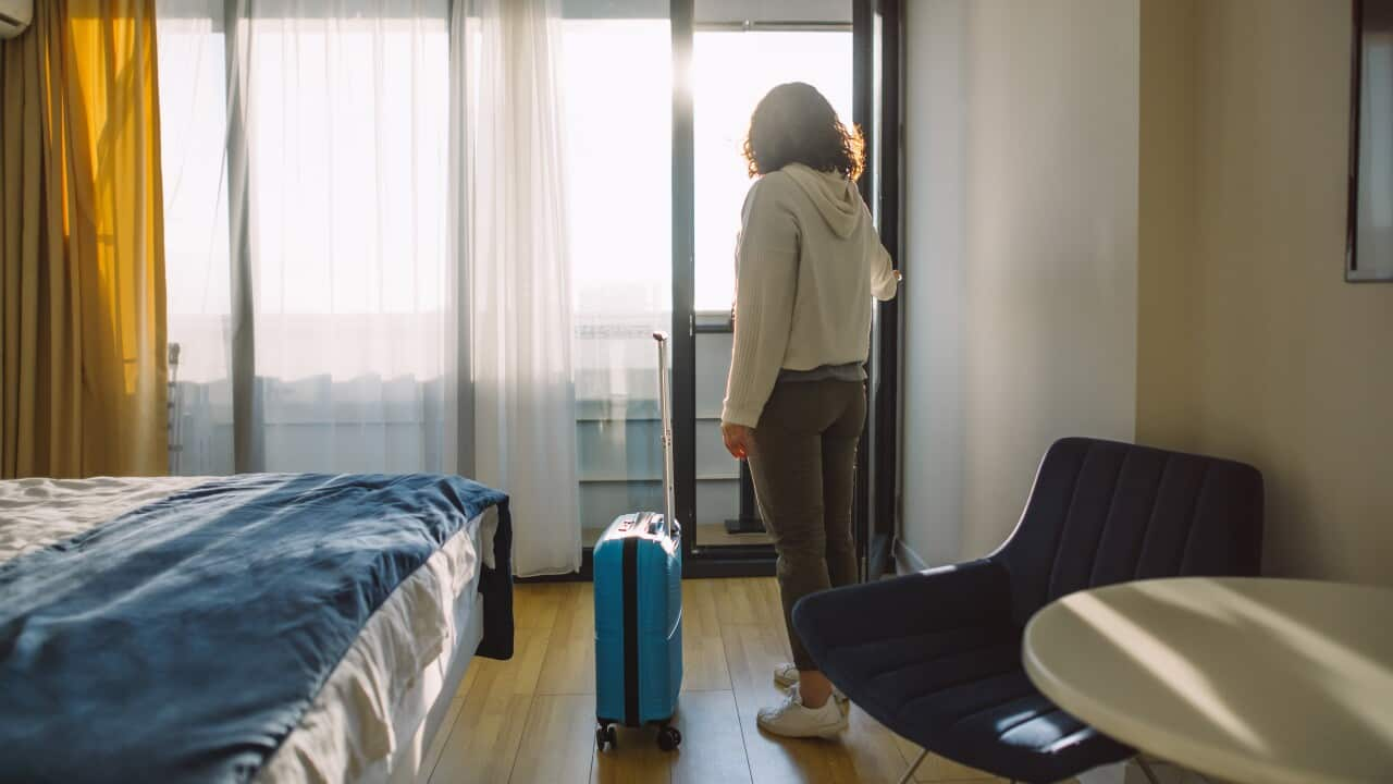 Woman with a suitcase in a room.