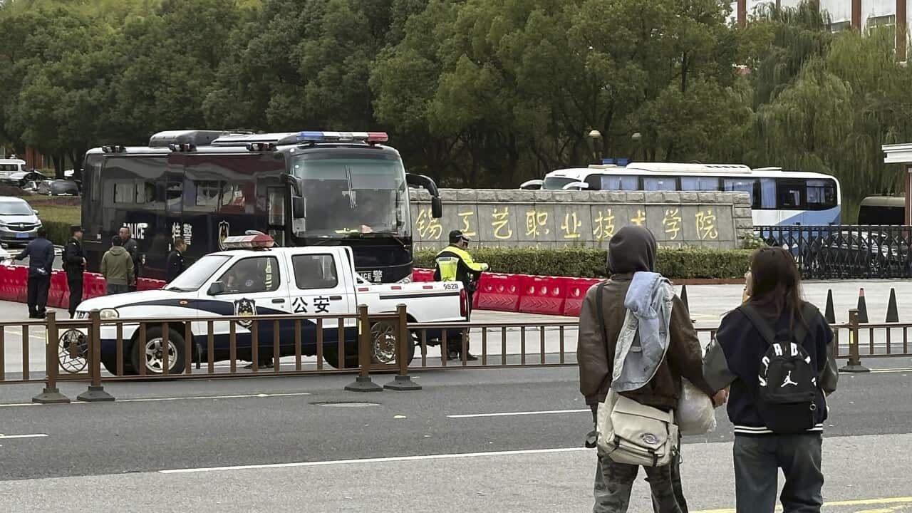 Some vehicles parked and a rear view of two people walking outside