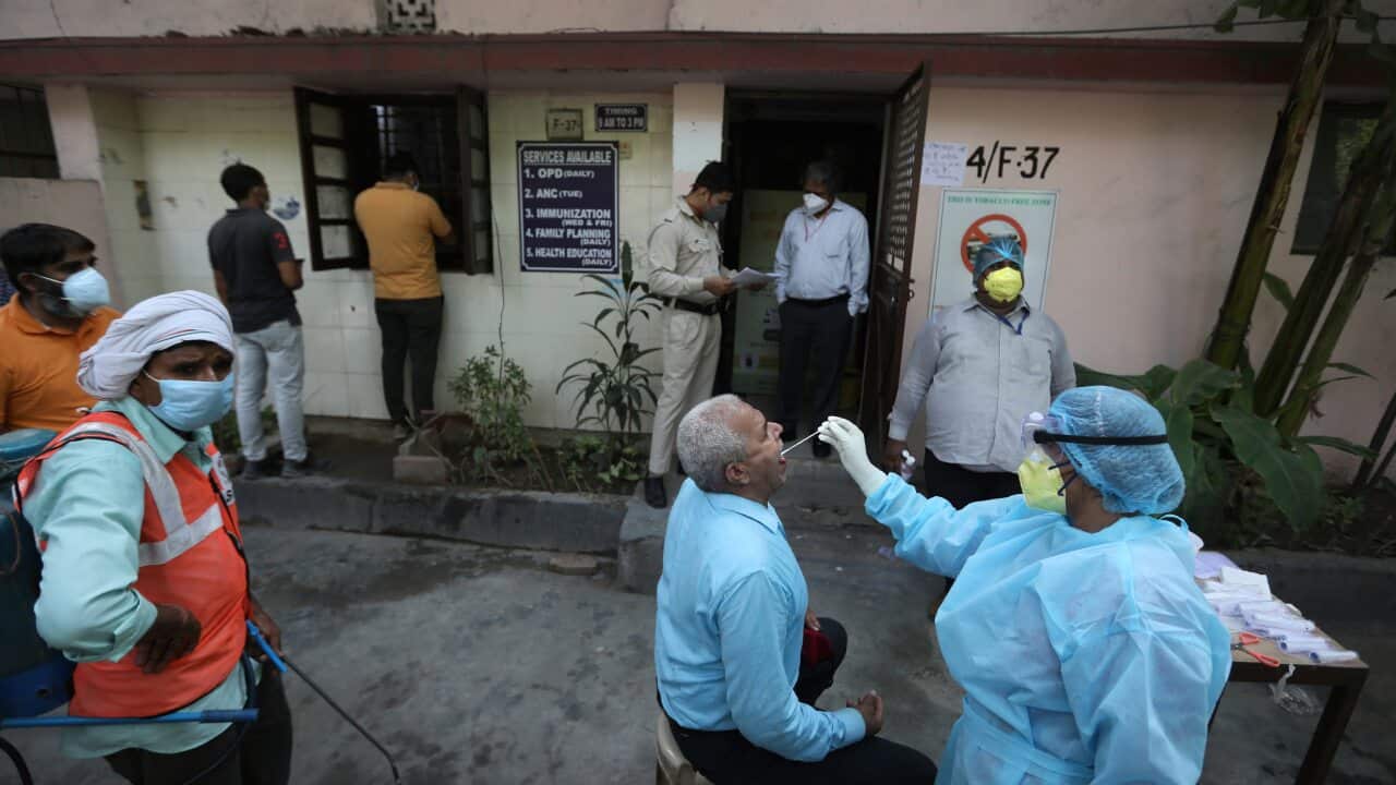 A health worker takes a swab test of an elderly man for COVID 19 in New Delhi, India.