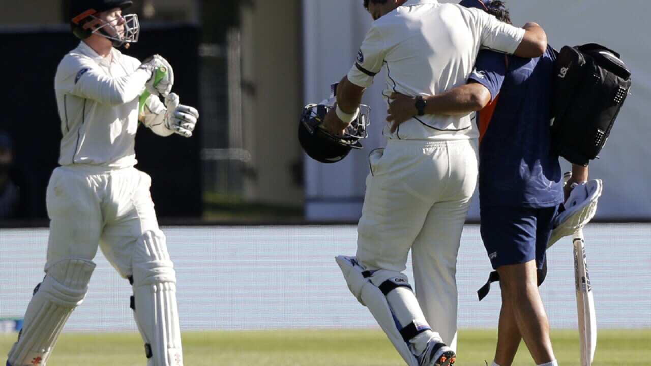 Ross Taylor is assisted from the field after injuring his leg