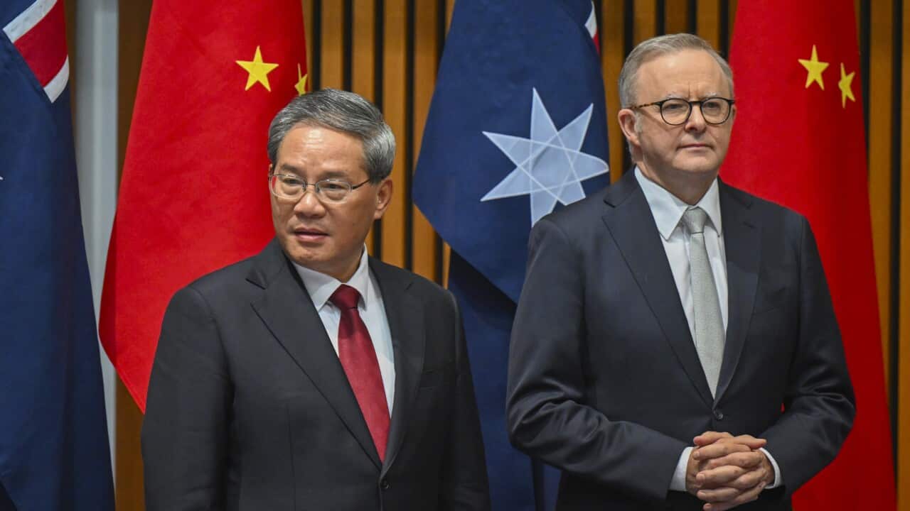 Chinese premier Li Qiang and Australian Prime Minisster Anthony Albanese standing in front of Australian and Chinese flags.