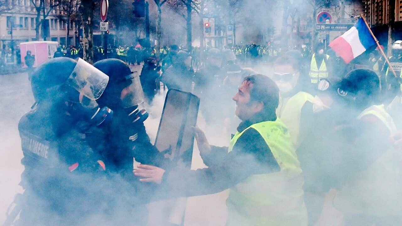 Demonstrators clash with riot police during a protest of Yellow vests (Gilets jaunes) against rising oil prices and living costs.