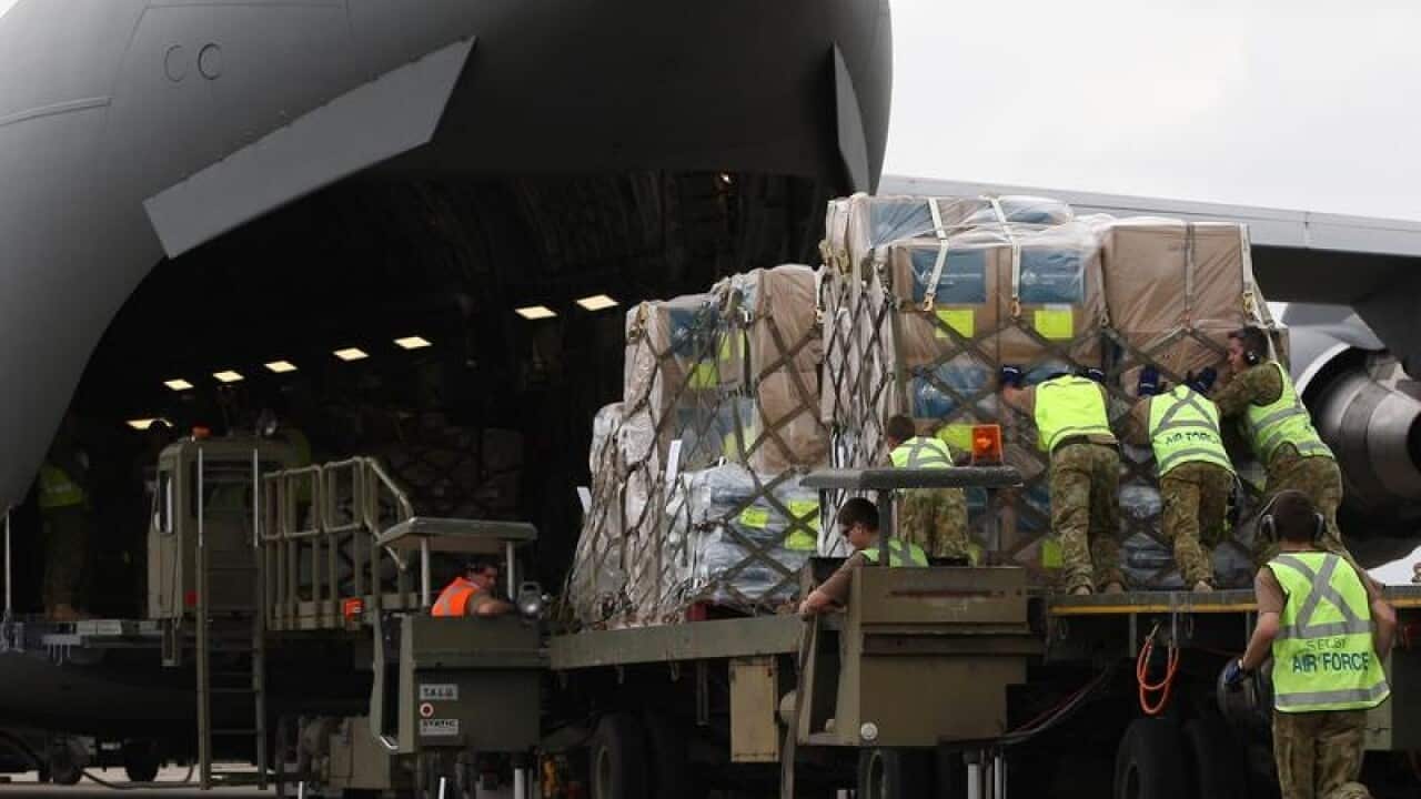 Air movements staff load humanitarian aid onto C-17A Globemaster III.
