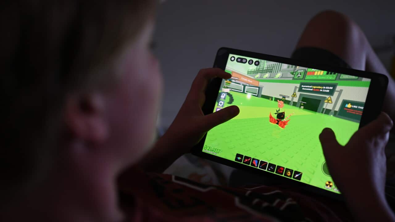 Over the shoulder view of child playing game on tablet