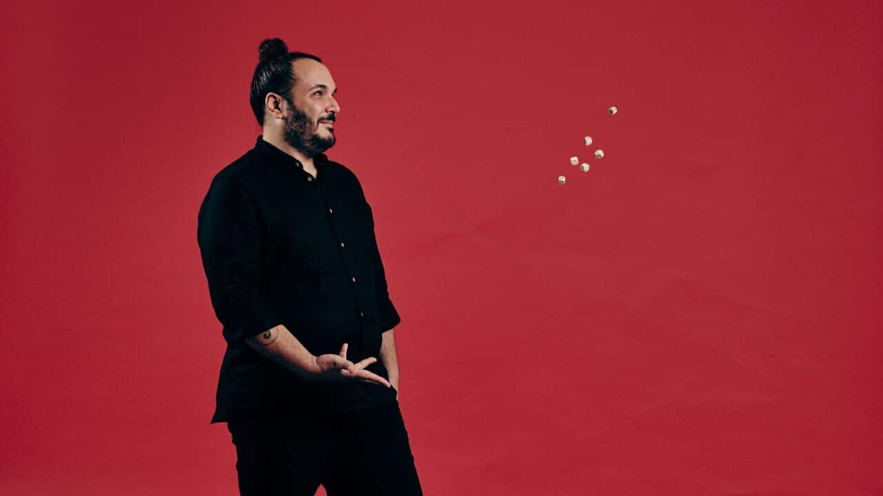 The singer songwriter Blindur throwing dice against a red background.