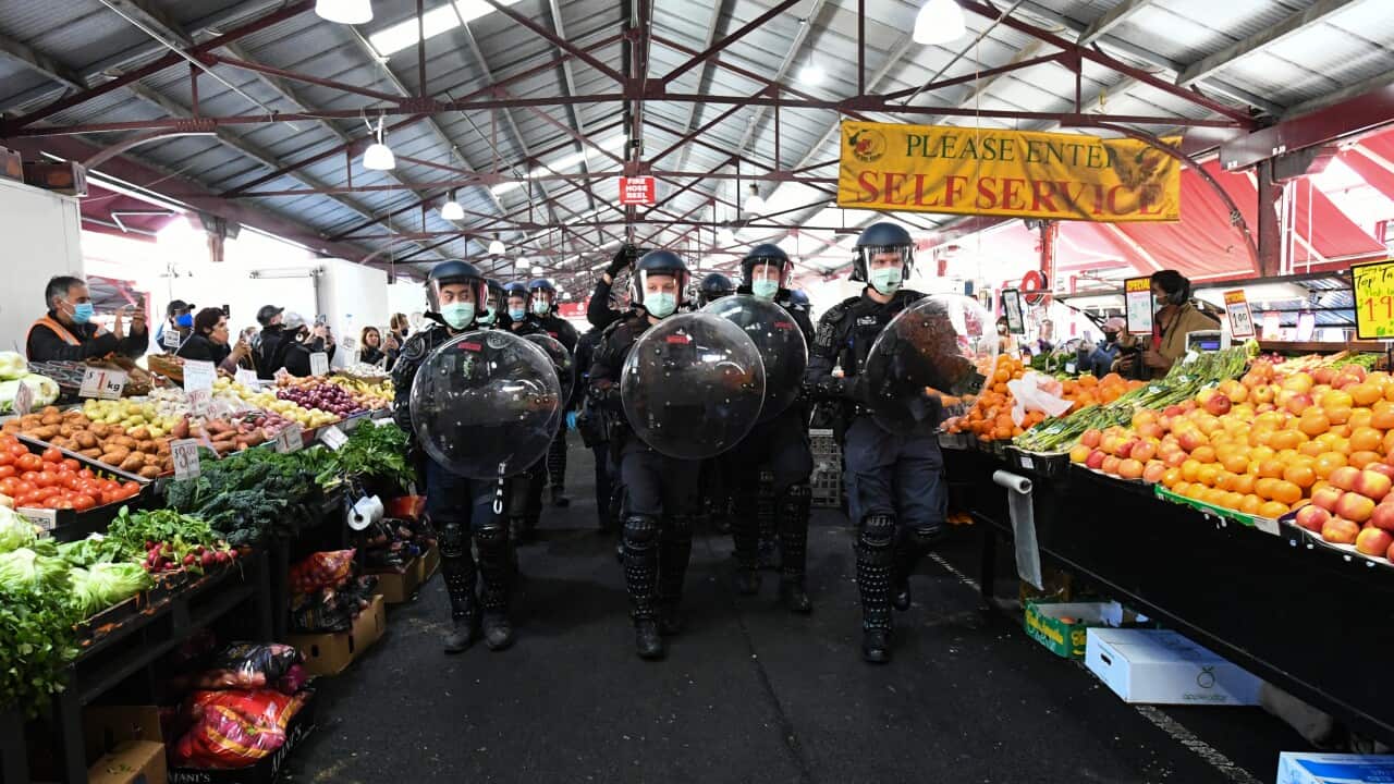 Police move protesters on through the Queen Victoria Market during an anti-lockdown protest in Melbourne.