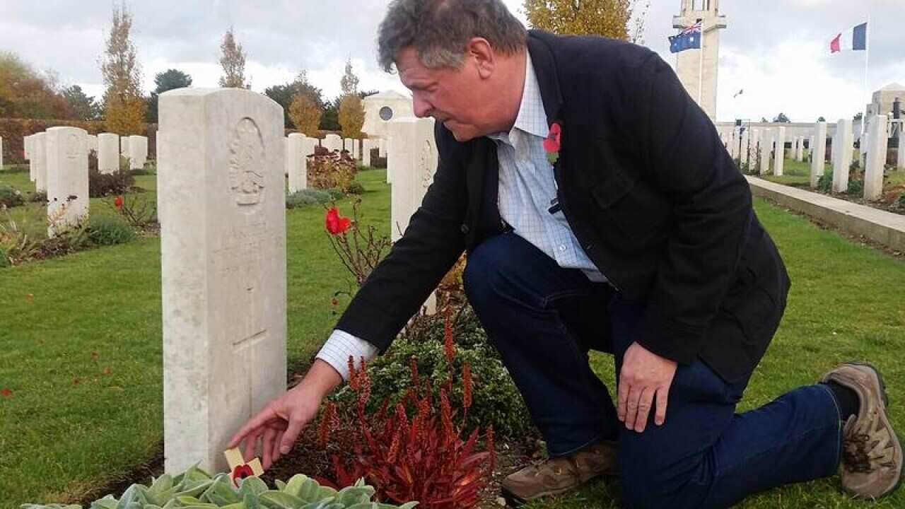 Australian Stephen Walls lays a tribute on a grave.