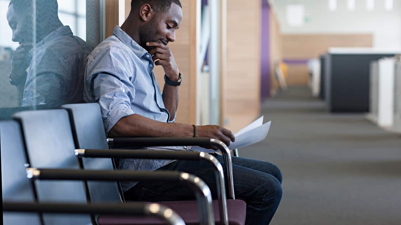 Man sitting on chair reading document