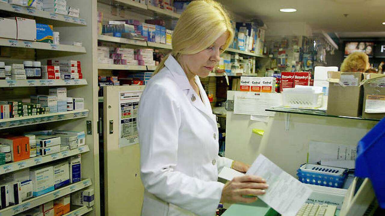 A pharmacist processes a prescription at