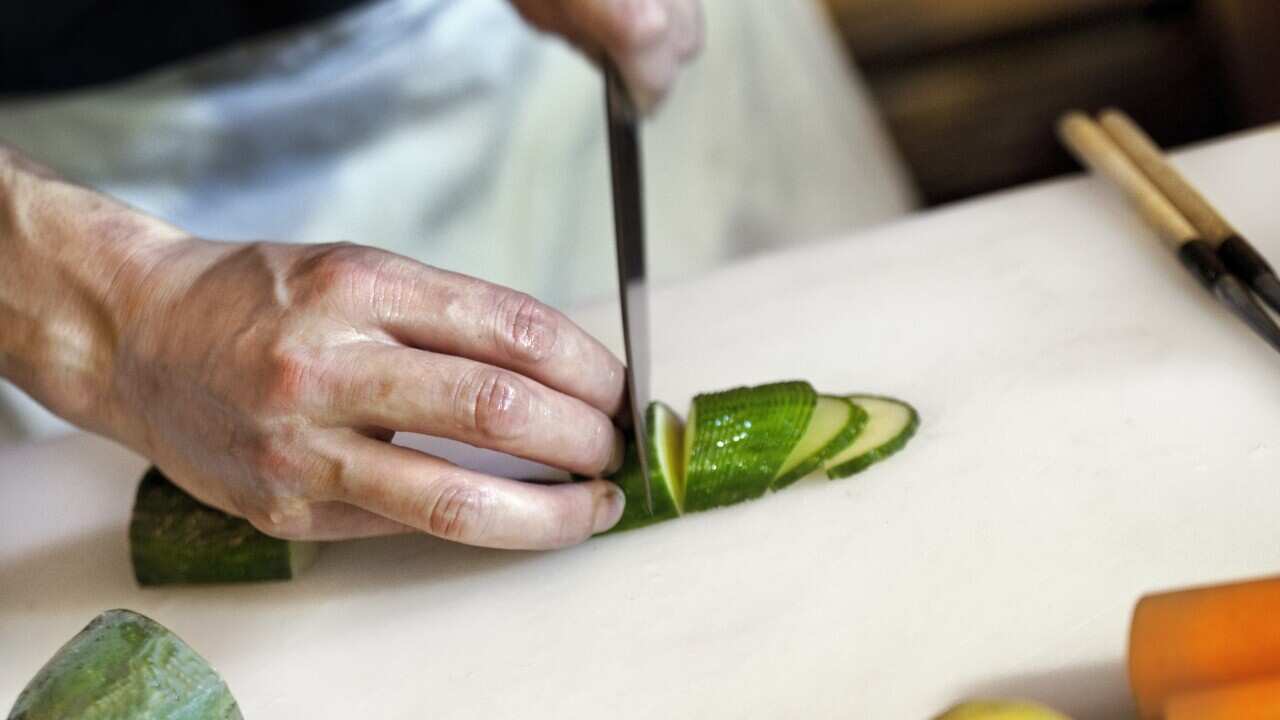 Cutting vegetable on the table of a restaurant kitchen