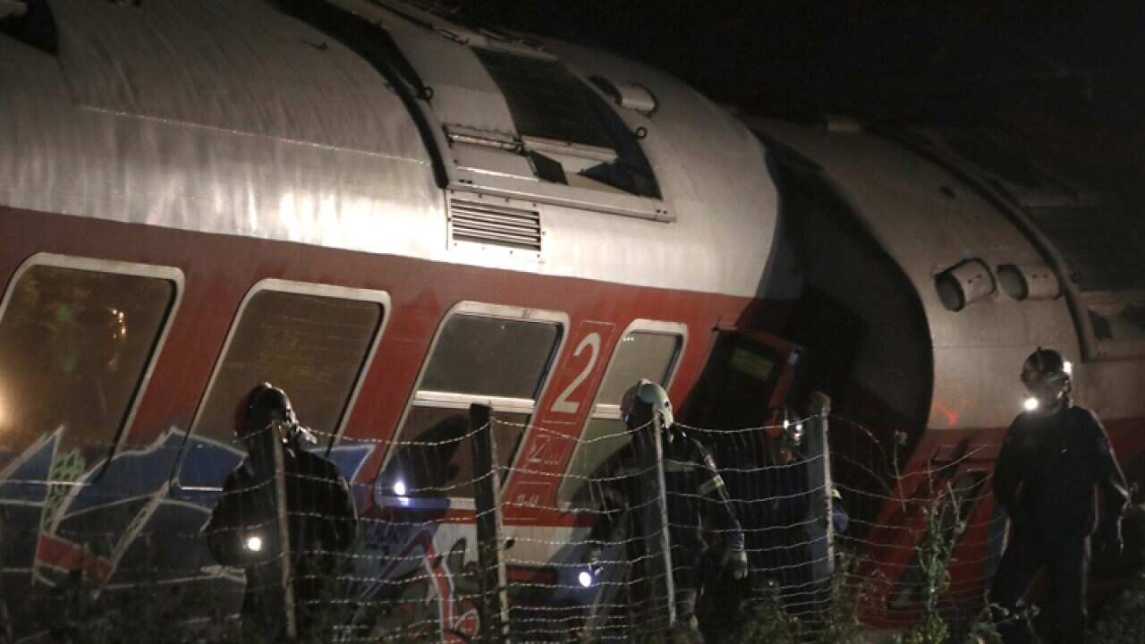 Rescuers search a site of a passenger train accident in Greece