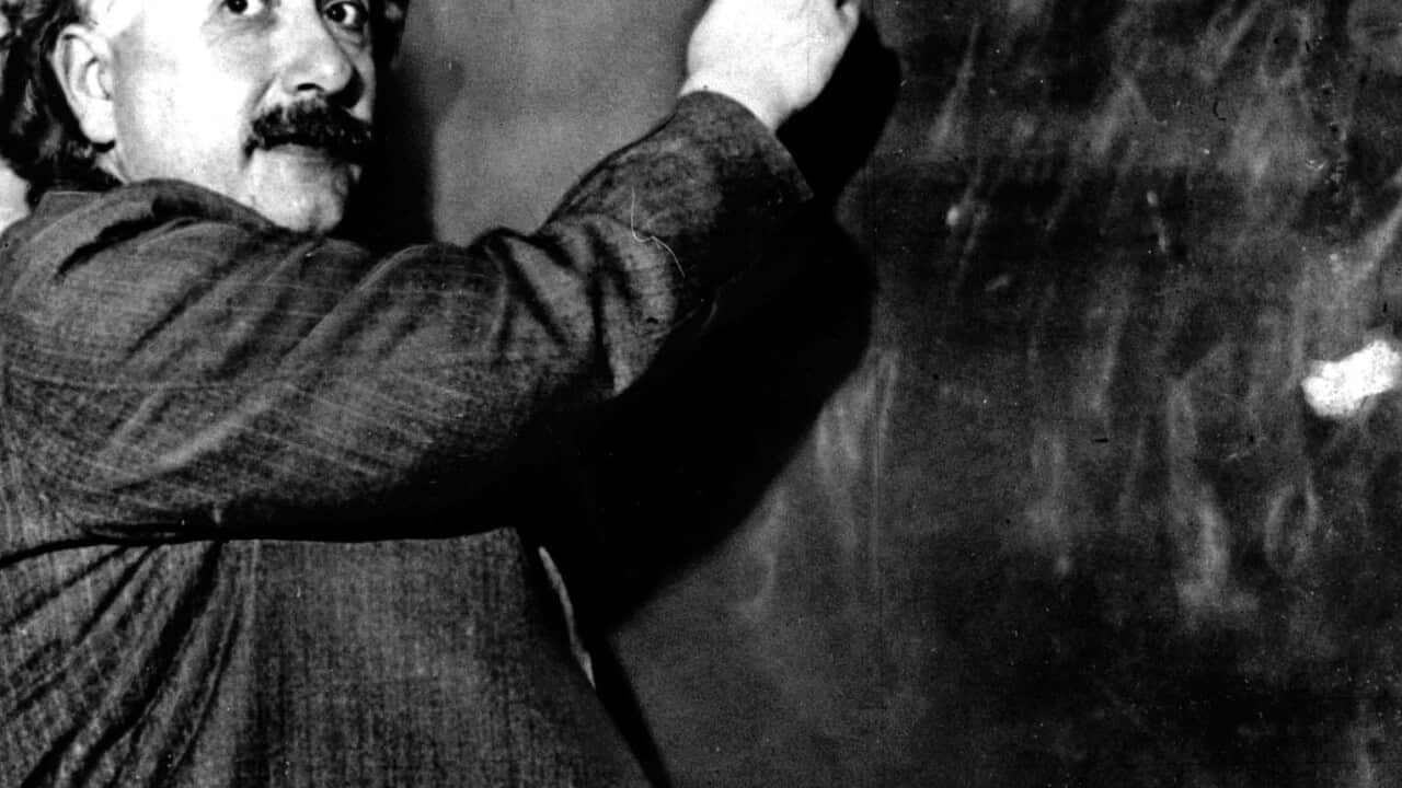 Albert Einstein writes out an equation for the density of the Milky Way on the blackboard at the Carnegie Institute 1931. 