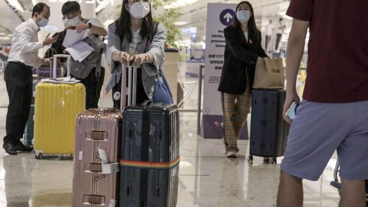 A woman pushes luggage through Changi Airport in Singapore