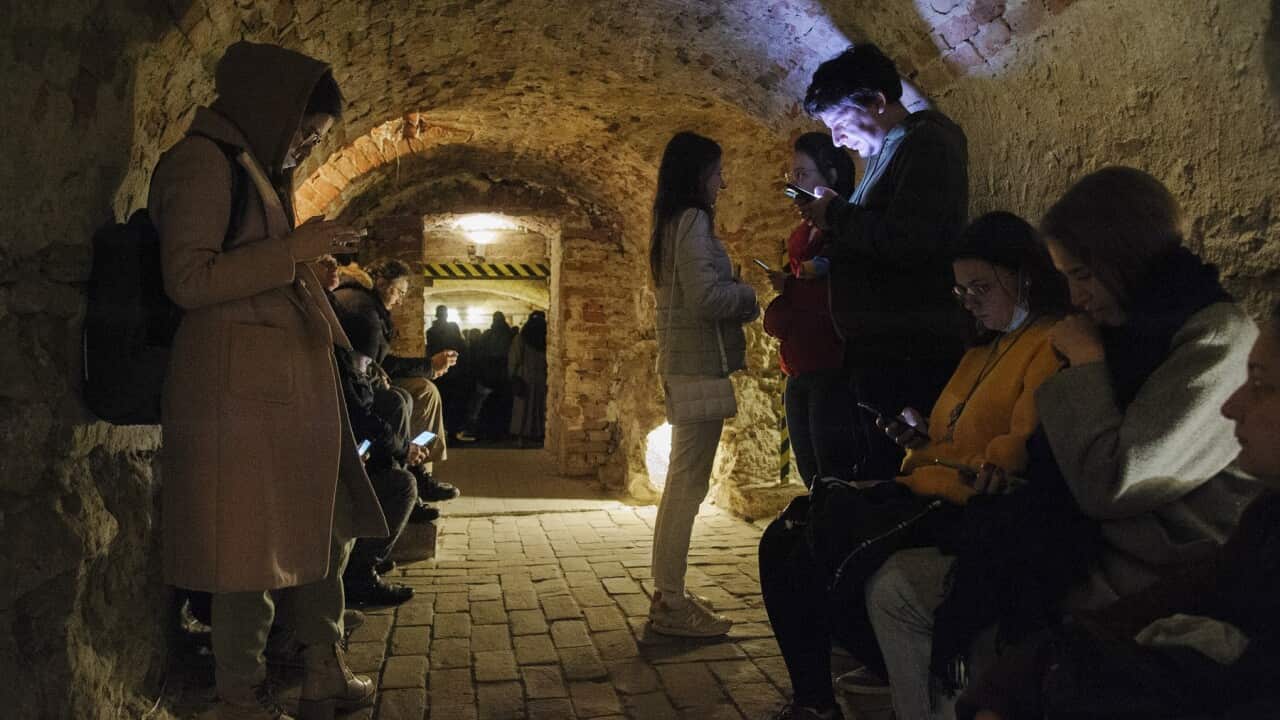 People in Lviv shelter in the basement of a historical building during an air raid warning.