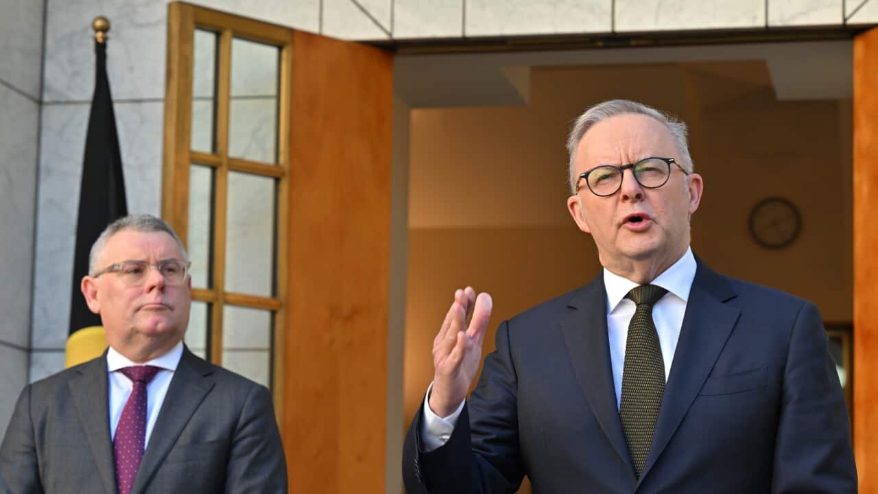 Anthony Albanese waving his hand and speaking, with Murray Watt in the background.
